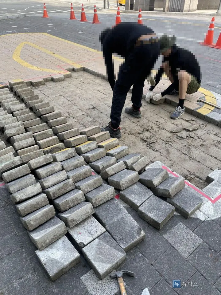 걷어낸 보도블럭을 옆으로 세워 두고 바닥을 정리하는 모습