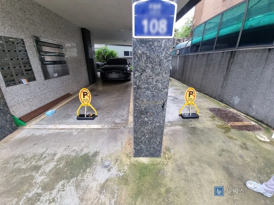 기둥 좌우 주차면에 각각 설치된 접이식 차단기 두 대