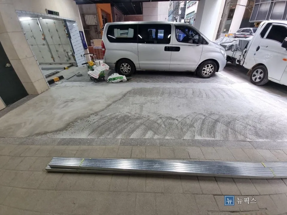 작업 전 주차 공간 전경과 바닥에 놓인 자재
