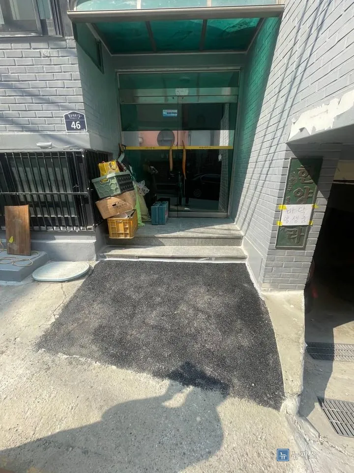 아스콘 시공을 마치고 양생 안내문을 붙인 빌라 입구