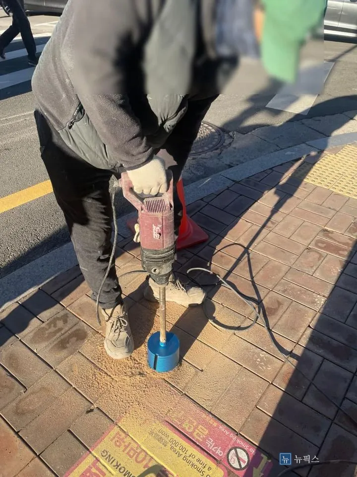코어 드릴로 보도블럭에 볼라드 매립 홀을 타공하는 모습