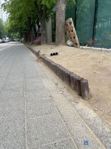인도를 따라 기울고 헐거워진 나무 화단 경계목