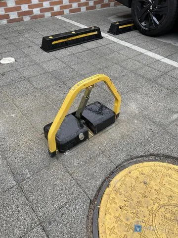 앙카로 고정을 마치고 봉을 세운 노란 접이식 주차금지대