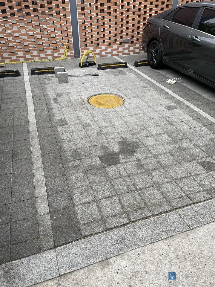 맨홀 뚜껑이 있는 지정 주차면 전경과 옆에 세워진 차량