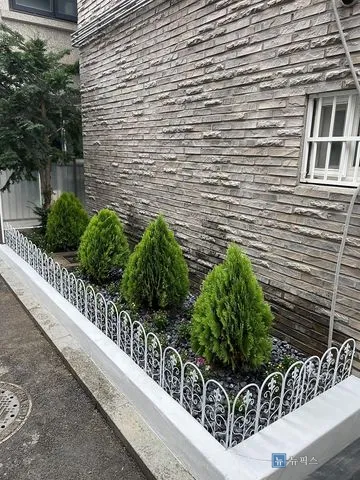 흰색으로 도색한 담장과 자갈을 깔고 울타리를 세운 화단