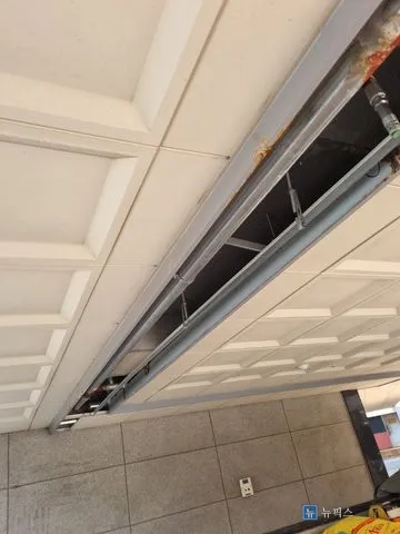 천장재가 걷어내진 필로티 주차장 천장과 녹이 번진 철제 프레임