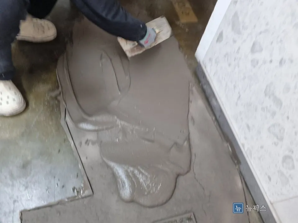 흙손으로 철거 부위에 미장하는 모습
