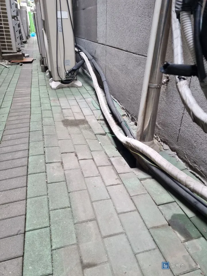 실외기 옆 통로를 따라 길게 꺼져 있는 보도블럭 구간