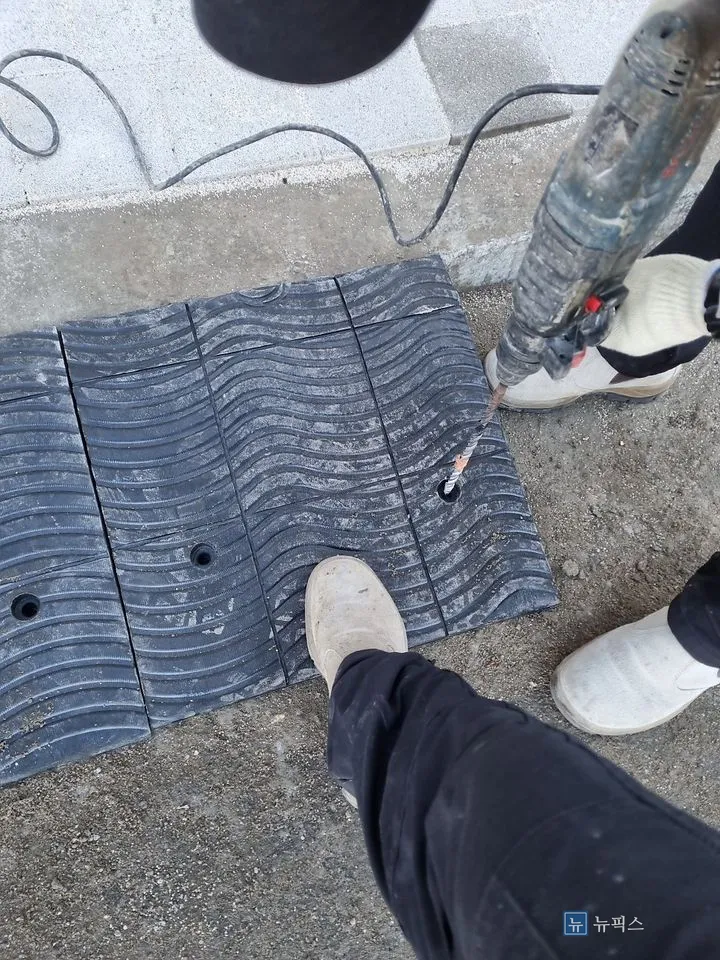 함마드릴로 고무 진입판 고정 구멍을 천공하는 모습