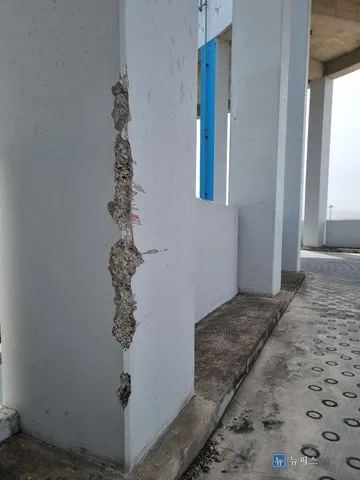 모서리를 따라 길게 파손되어 골재가 드러난 주차장 기둥