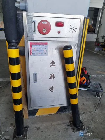 볼라드 사이에 설치된 기둥 옥내소화전, 스텐 문짝이 찌그러진 상태