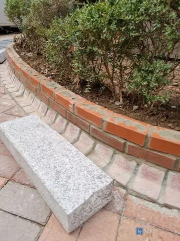 새 벽돌로 복구를 마친 담장 상단과 메지가 채워진 줄눈