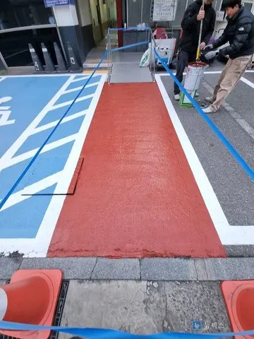 도장을 마치고 보양 줄을 친 보행로와 옆 장애인주차구역